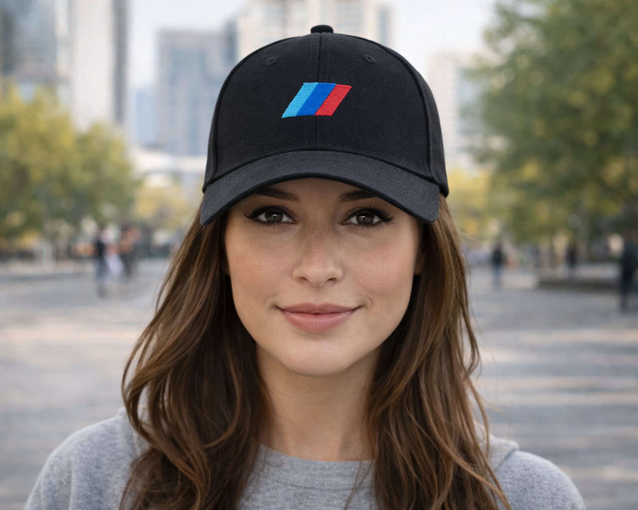 Woman wearing a black cap with a logo in an outdoor setting