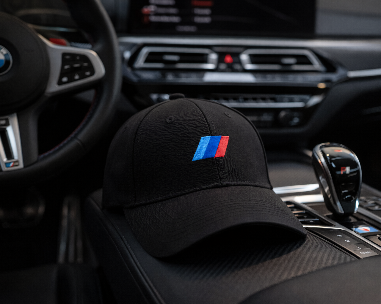 Black cap with BMW logo on car dashboard